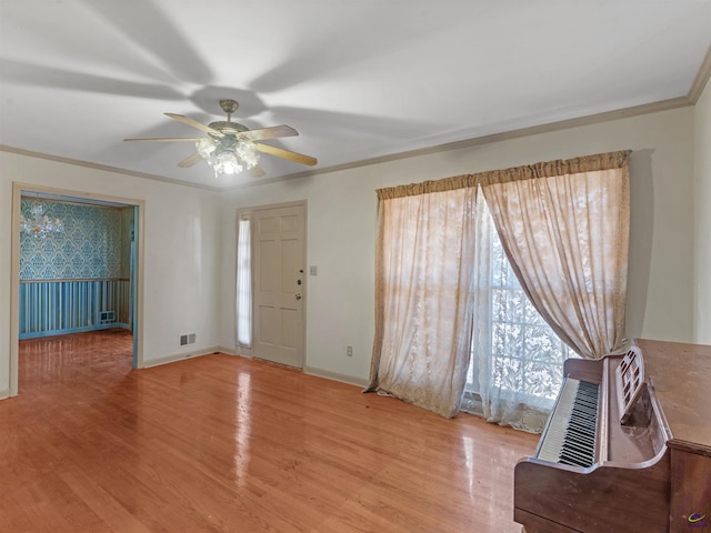 foyer entrance featuring light wood-style floors, crown molding, baseboards, and ceiling fan