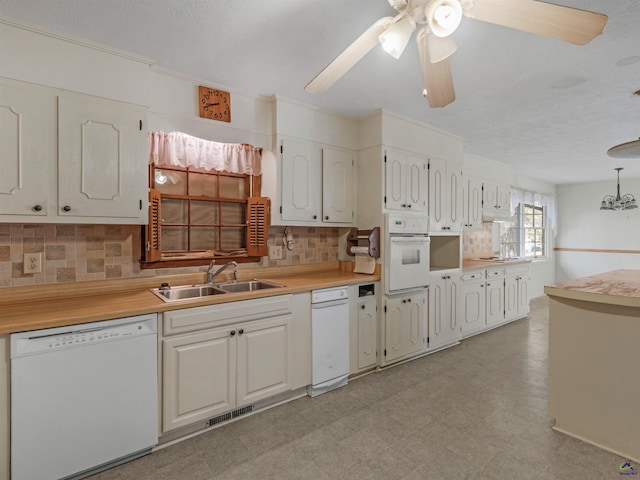 kitchen with white appliances, a sink, visible vents, light countertops, and tasteful backsplash