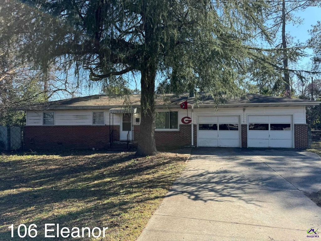 single story home featuring a garage, driveway, and brick siding