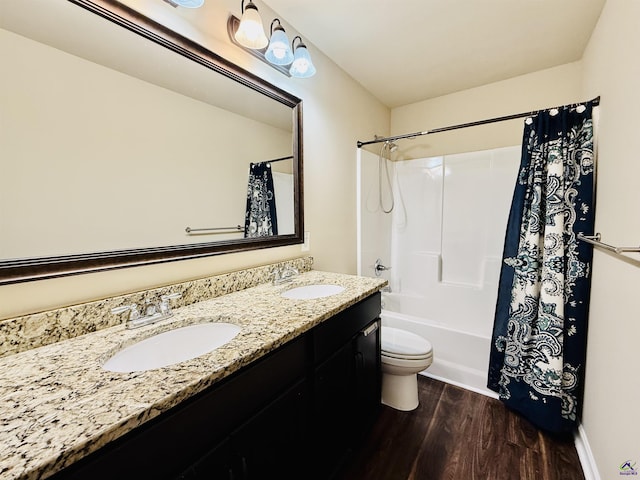 bathroom with double vanity, wood finished floors, a sink, and shower / tub combo