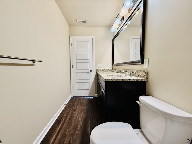 bathroom with baseboards, visible vents, vanity, and toilet