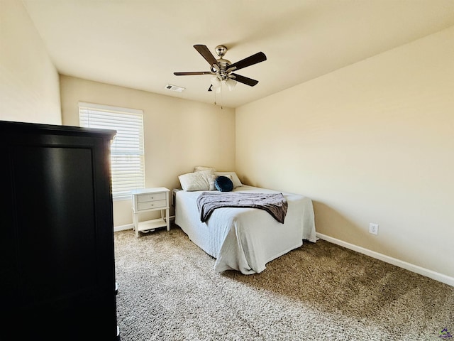 carpeted bedroom featuring a ceiling fan, visible vents, and baseboards