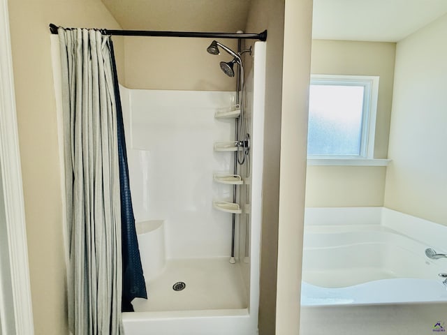 bathroom with a stall shower and a bath