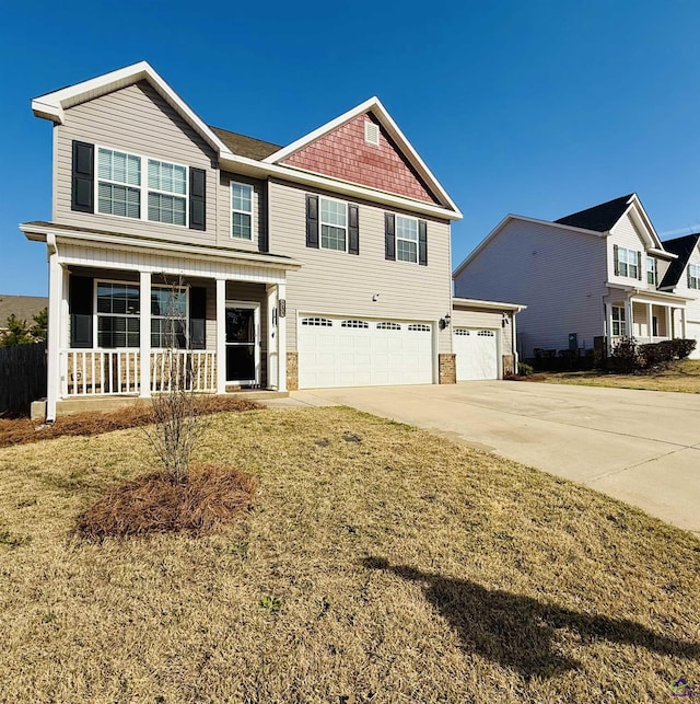 view of front of home featuring a porch, a front yard, driveway, and an attached garage