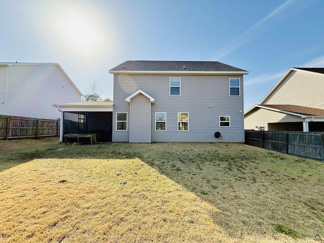 rear view of property with a sunroom, a fenced backyard, and a lawn