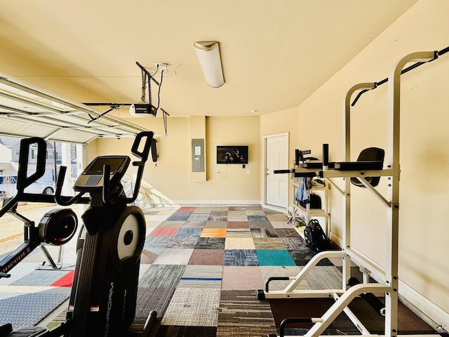 exercise room with a garage, electric panel, and baseboards