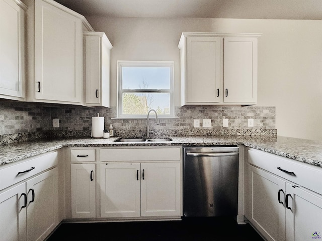 kitchen with tasteful backsplash, white cabinets, a sink, and stainless steel dishwasher