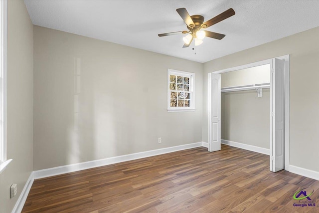 unfurnished bedroom featuring ceiling fan, a closet, baseboards, and wood finished floors