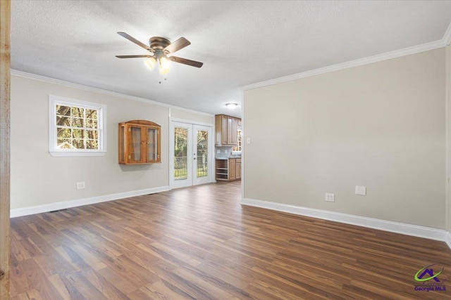 unfurnished living room with a textured ceiling, dark wood-style flooring, a ceiling fan, baseboards, and crown molding