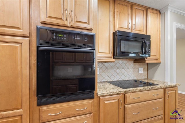 kitchen featuring black appliances, tasteful backsplash, wood finished floors, and light stone countertops