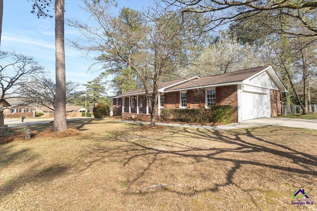 view of front of property featuring an attached garage, driveway, a front yard, and brick siding