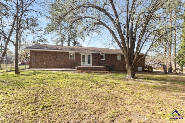 rear view of property with a patio area, french doors, brick siding, and a yard