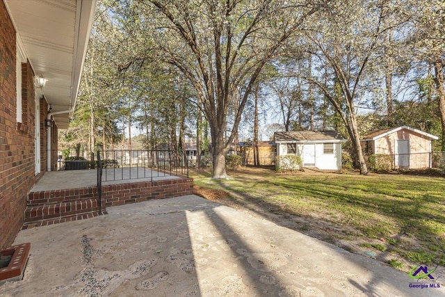 view of yard with a patio area, fence, and an outbuilding