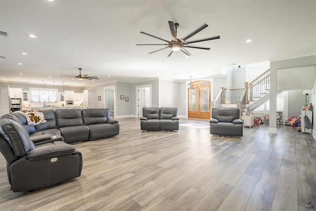 living area with light wood finished floors, stairway, crown molding, and recessed lighting