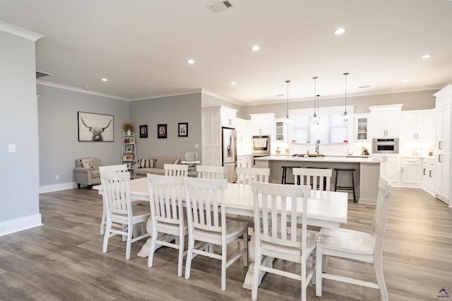 dining room with recessed lighting, visible vents, baseboards, light wood-style floors, and ornamental molding