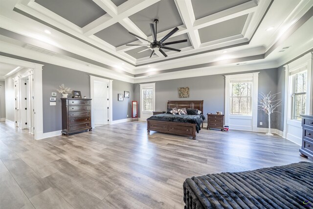 bedroom featuring coffered ceiling, crown molding, and light wood finished floors