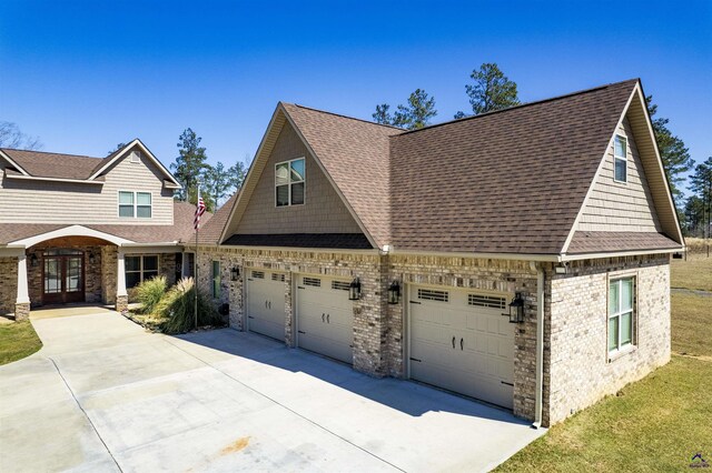 view of front of home with a shingled roof, french doors, and driveway