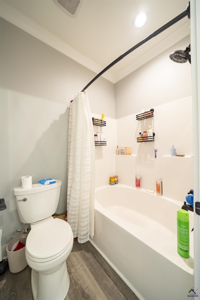 full bath featuring toilet, shower / bath combination with curtain, visible vents, and wood finished floors