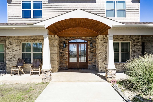doorway to property with covered porch and brick siding