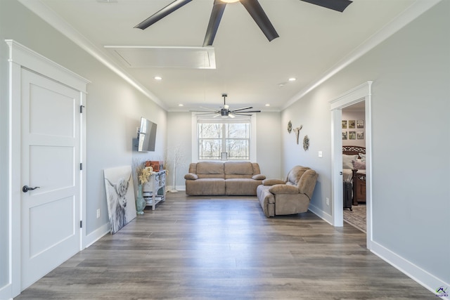 living room with attic access, a ceiling fan, crown molding, and wood finished floors