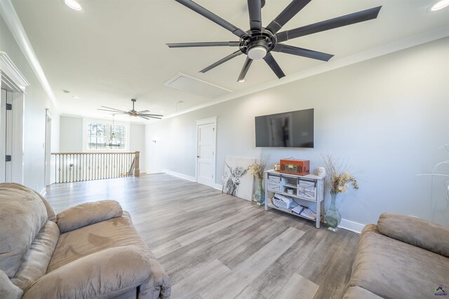 living area featuring crown molding, recessed lighting, attic access, wood finished floors, and baseboards