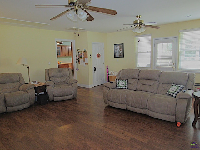 living area featuring baseboards, wood finished floors, a ceiling fan, and attic access