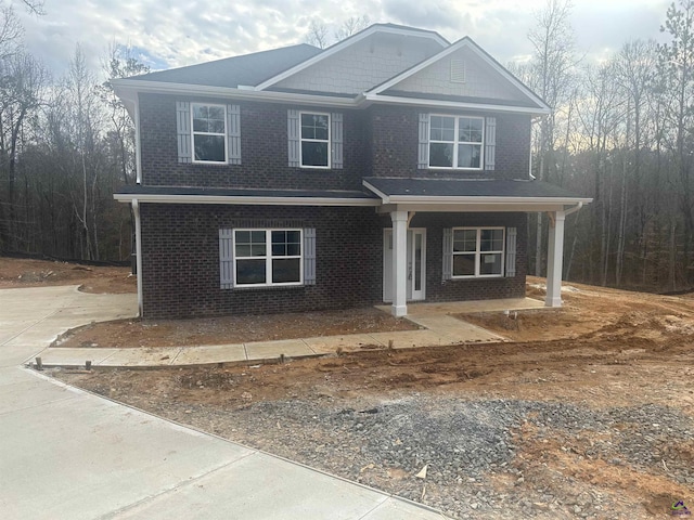 craftsman house featuring a porch and brick siding