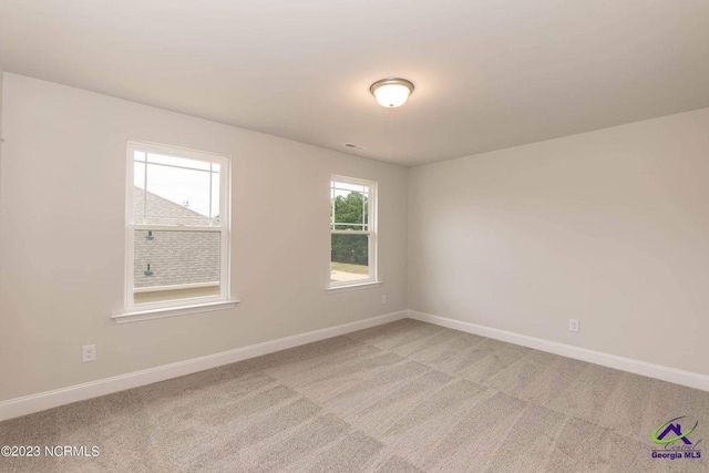 empty room with light carpet and baseboards