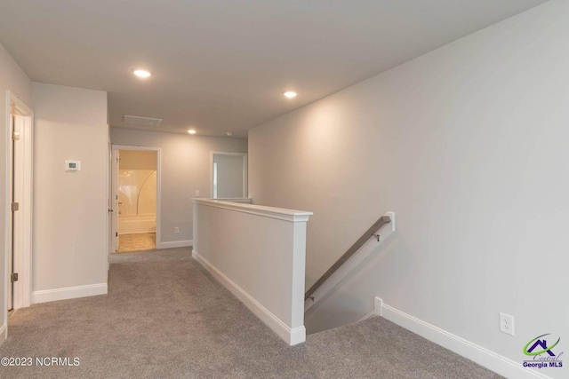 hall featuring recessed lighting, carpet, baseboards, and an upstairs landing