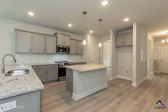 kitchen featuring stainless steel appliances, gray cabinets, and a sink