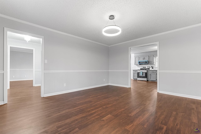 empty room with dark wood-style floors, a textured ceiling, baseboards, and crown molding