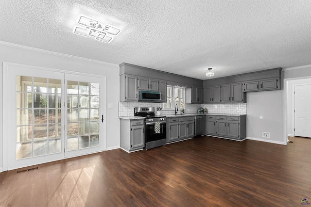 kitchen with dark wood-style floors, visible vents, stainless steel appliances, and gray cabinetry
