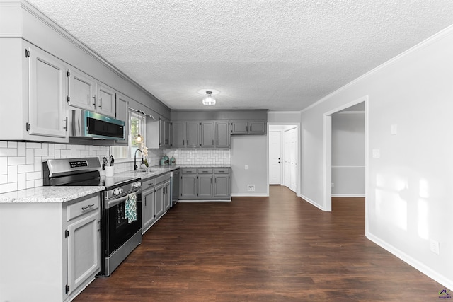 kitchen featuring crown molding, appliances with stainless steel finishes, backsplash, and dark wood-type flooring