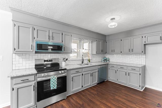 kitchen with dark wood-style floors, crown molding, decorative backsplash, appliances with stainless steel finishes, and a sink