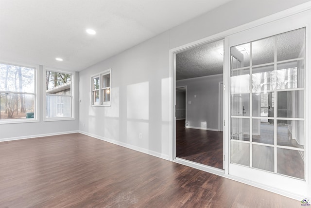 spare room with baseboards, dark wood finished floors, a textured ceiling, and recessed lighting
