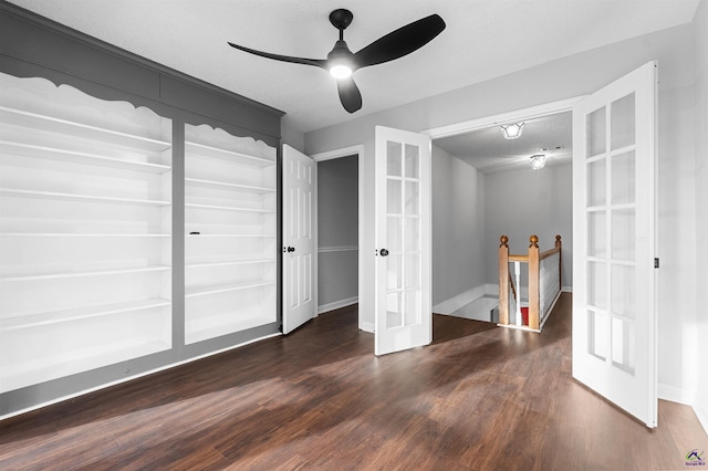 interior space featuring dark wood-style flooring, french doors, ceiling fan, a textured ceiling, and baseboards