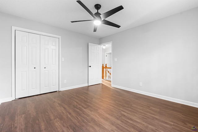 unfurnished bedroom with ceiling fan, a closet, wood finished floors, and baseboards