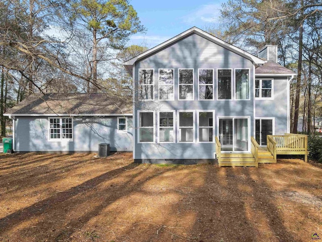 rear view of property with a sunroom, central AC, a chimney, and a wooden deck