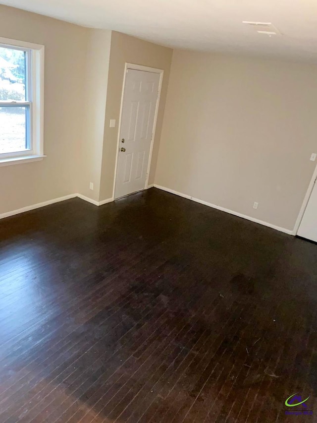 unfurnished room with wood-type flooring and baseboards