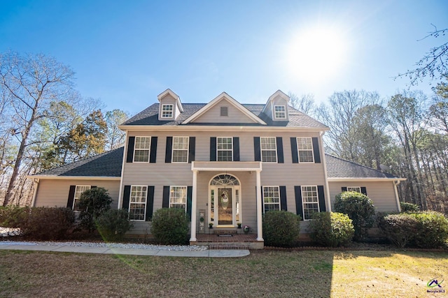 view of front of home with a shingled roof and a front lawn