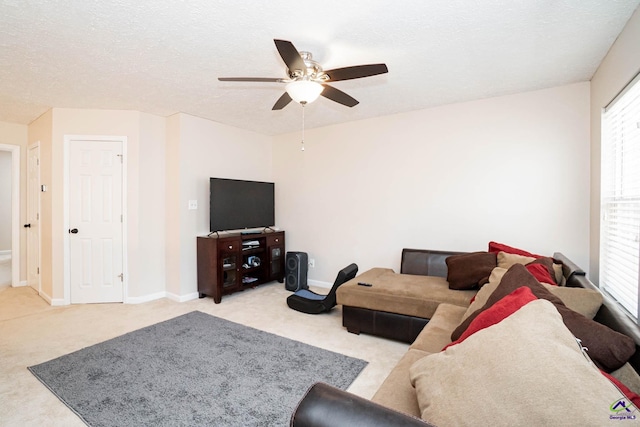 carpeted living room with a textured ceiling, ceiling fan, and baseboards