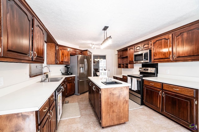 kitchen featuring light countertops, appliances with stainless steel finishes, a sink, and a center island