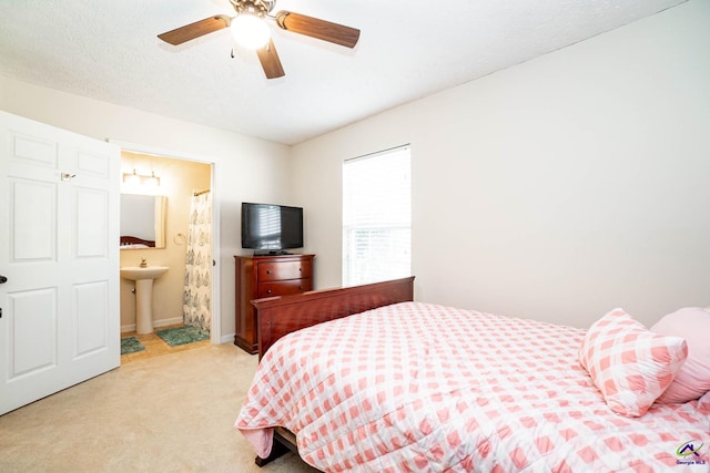 bedroom featuring light carpet, ceiling fan, a textured ceiling, and ensuite bathroom