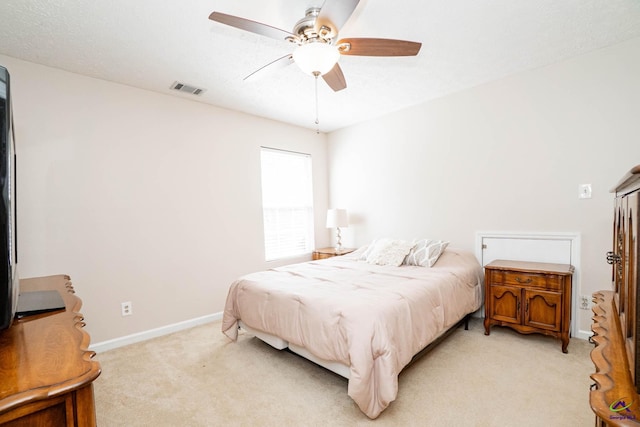 bedroom with baseboards, ceiling fan, visible vents, and light colored carpet