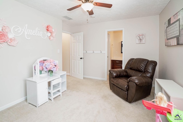 sitting room featuring visible vents, light colored carpet, a textured ceiling, and baseboards