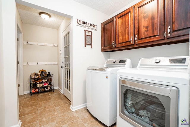 laundry room featuring cabinet space, baseboards, washer and clothes dryer, and a textured ceiling