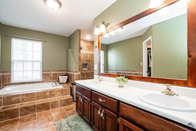 full bath with a garden tub, a fireplace, a sink, and tile patterned floors