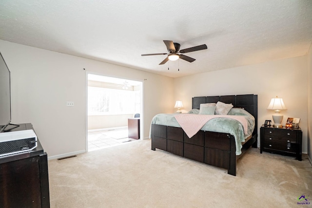 carpeted bedroom featuring a ceiling fan, visible vents, a textured ceiling, and baseboards