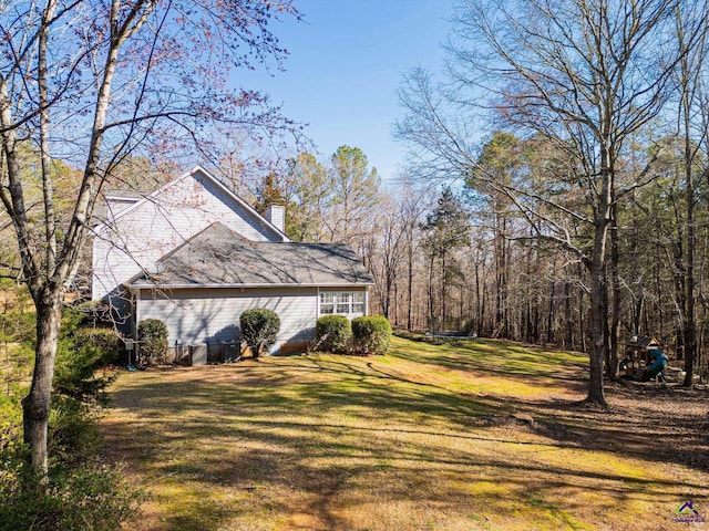 view of home's exterior featuring a chimney and a lawn