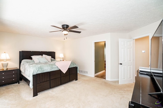 bedroom featuring a textured ceiling, ceiling fan, light colored carpet, visible vents, and baseboards